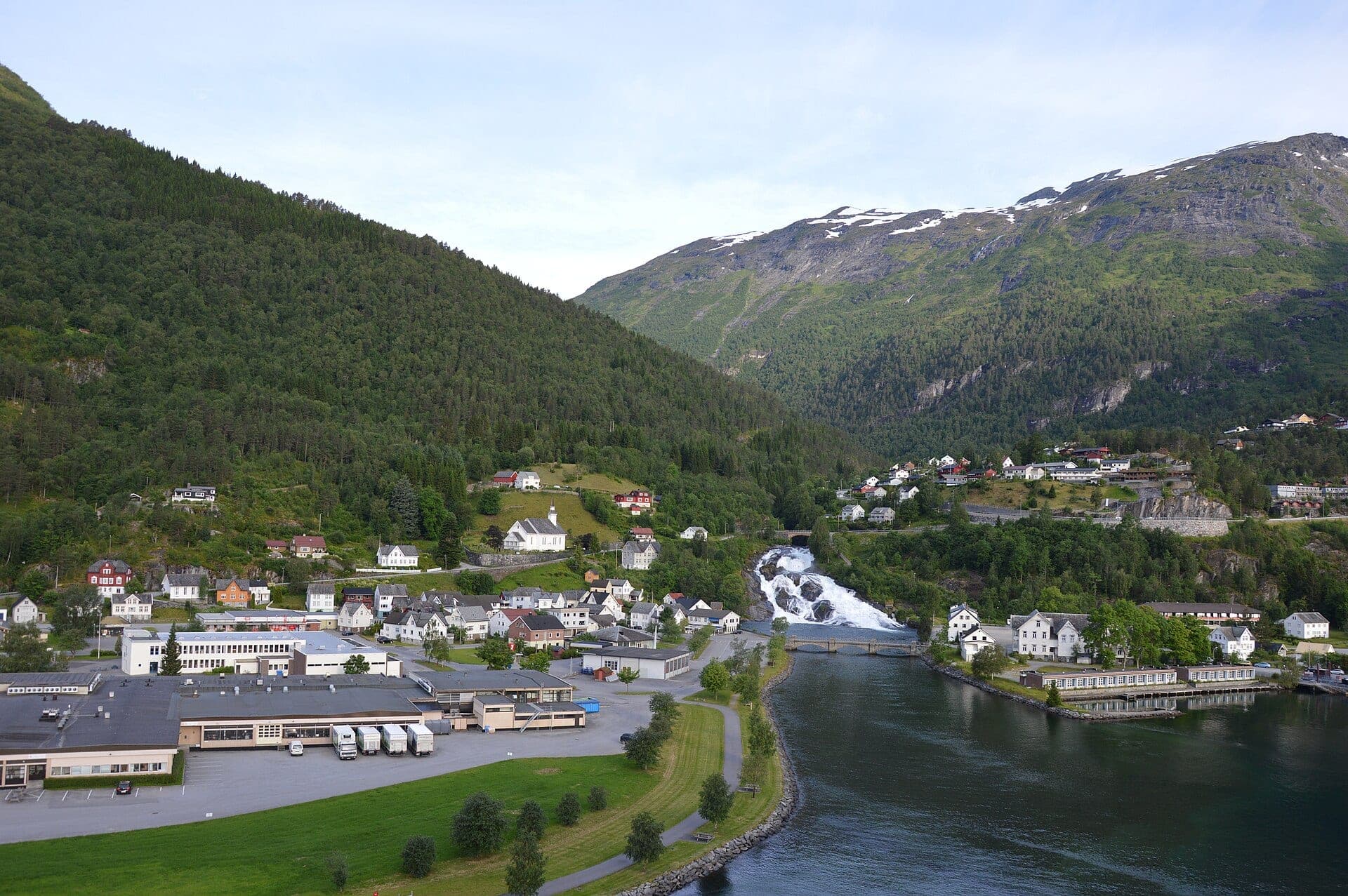 Hellesyltfossen through the middle of the village, the ship at the quay behind it